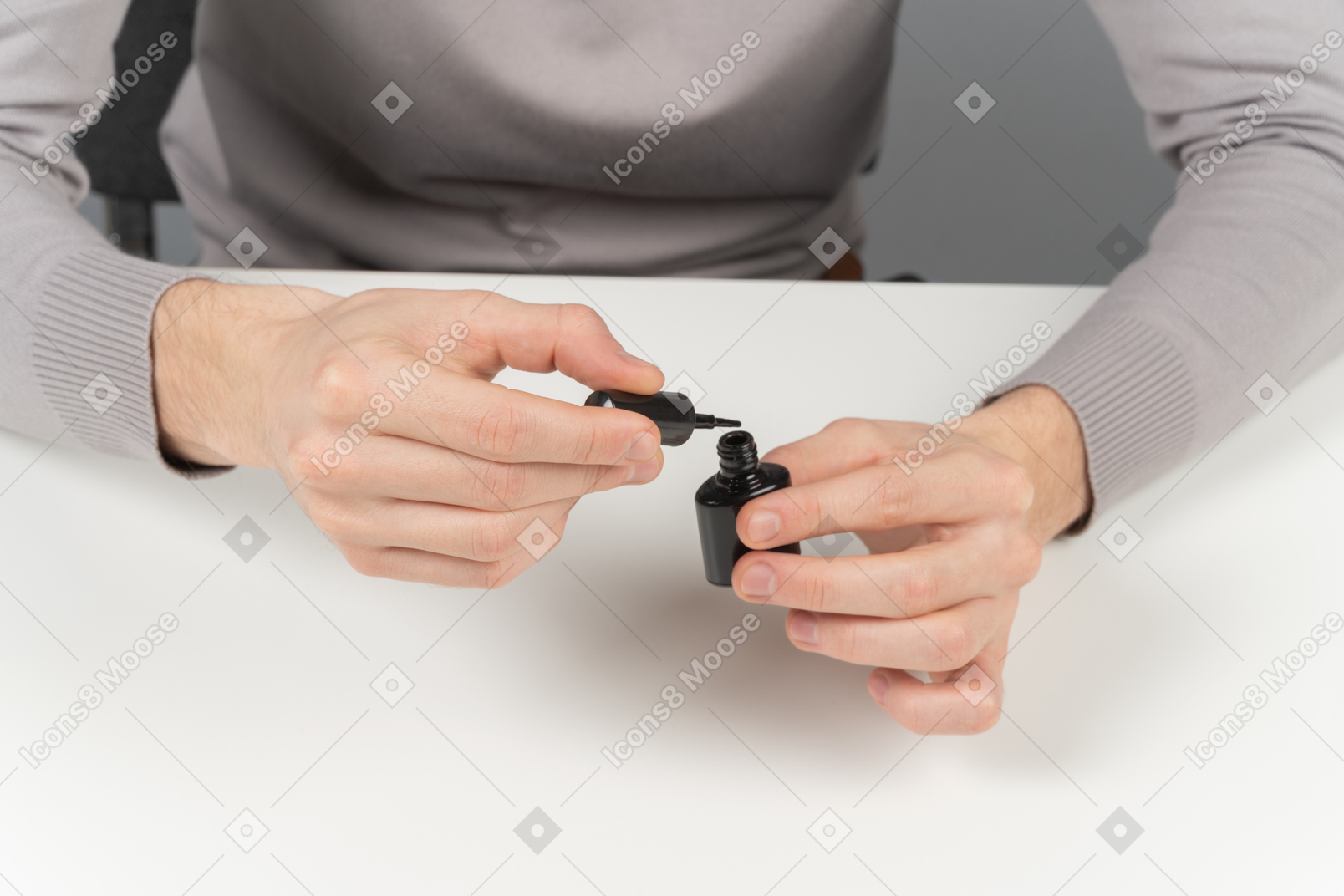 A man opening a black nail polish