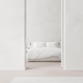 Entrance to a minimalistic bedroom with white walls and a king size bed