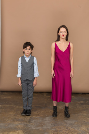 Front view of a boy in suit vest and young woman