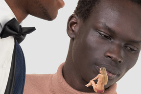 Man whispering into another man's ear and small picture of woman in front of them