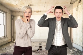 A man and a woman standing in an empty room