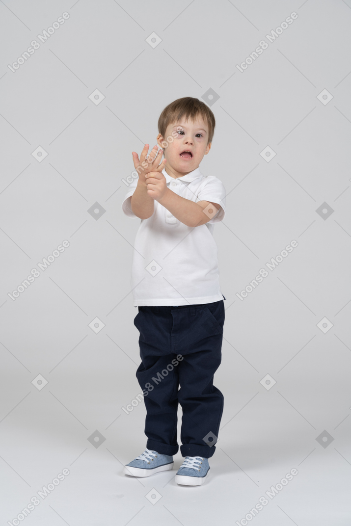Surprised little boy squeezing his hand
