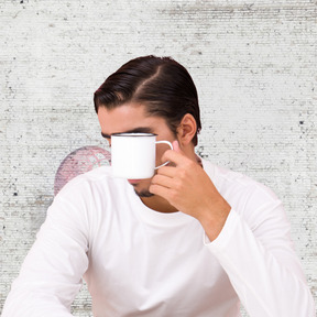 A man holding a cup of coffee in front of his face