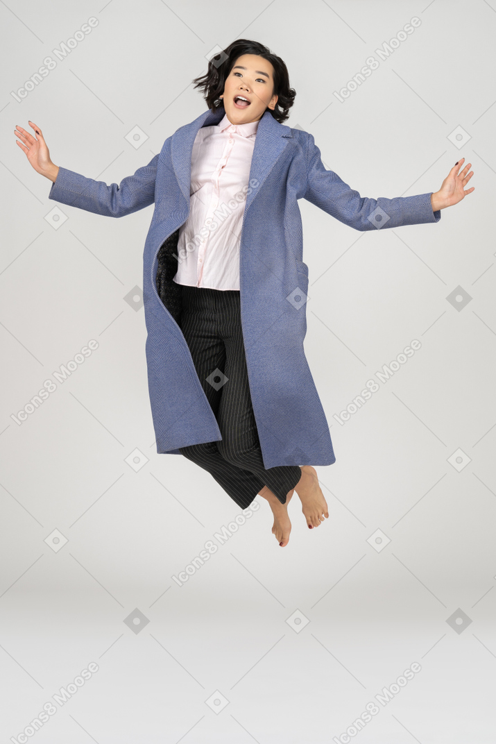 Young woman mid-air with spread hands