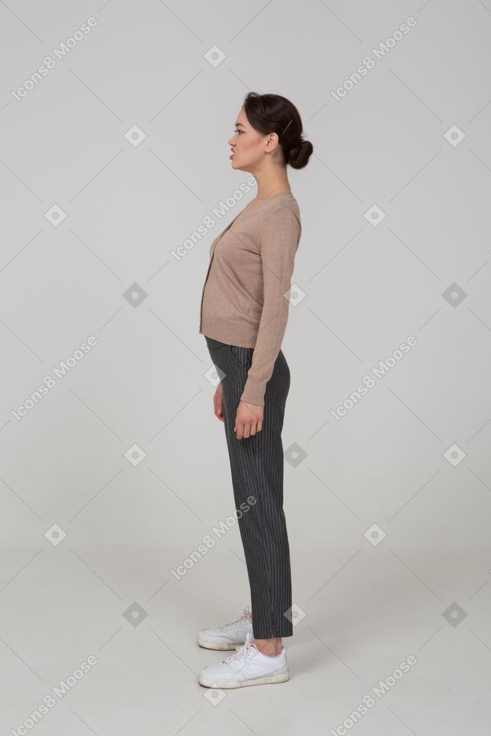 Side view of a displeased lady in pullover and pants looking aside