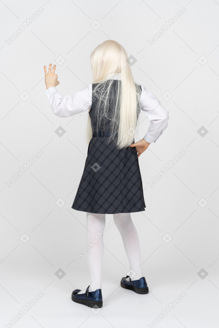 Back view of a schoolgirl making okay sign