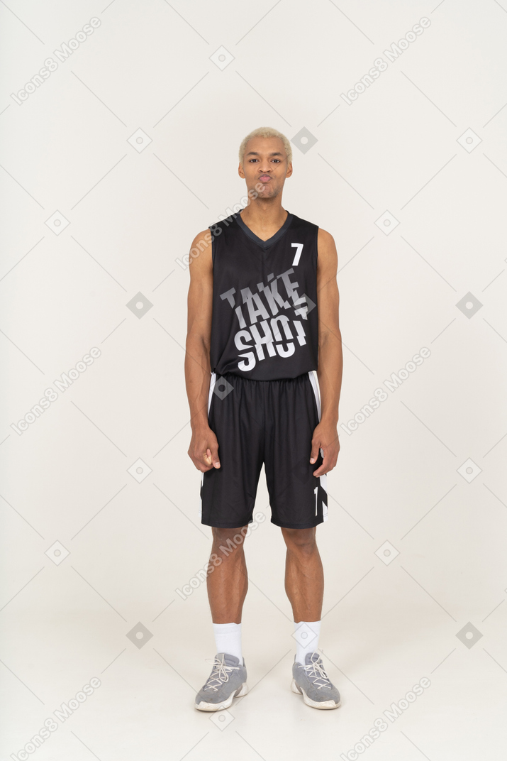 一个站着不动的撅嘴的年轻男篮球运动员的前视图