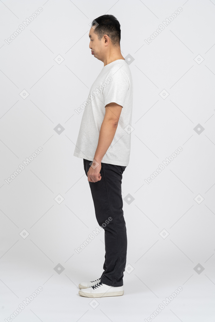 Side view of a man in casual clothes staring at something