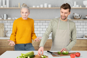 A man and a woman in a kitchen preparing food