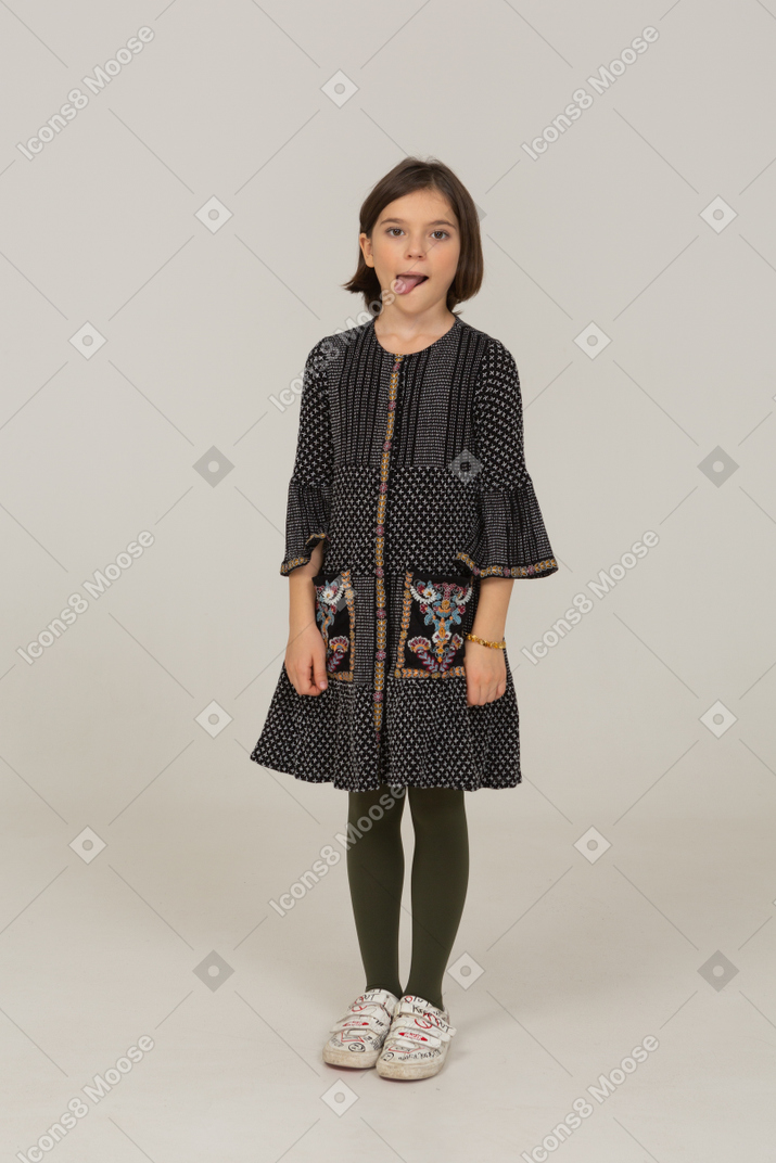 Front view of a little girl in dress licking lips