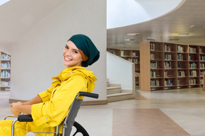 A smiling woman in a wheelchair at the library