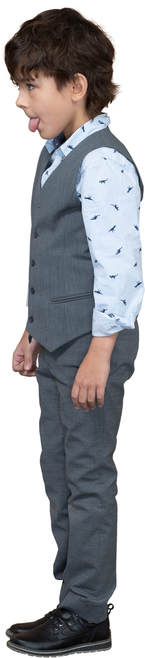 Side view of a boy in grey suit showing tongue