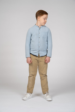 Vista frontal de um menino em roupas casuais, olhando de lado