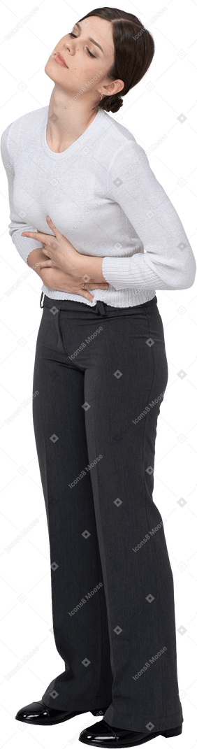 Three-quarter view of a young woman in office clothing touching stomach