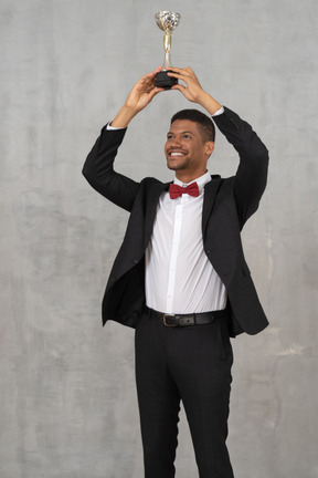 Man holding up award in celebration of his win