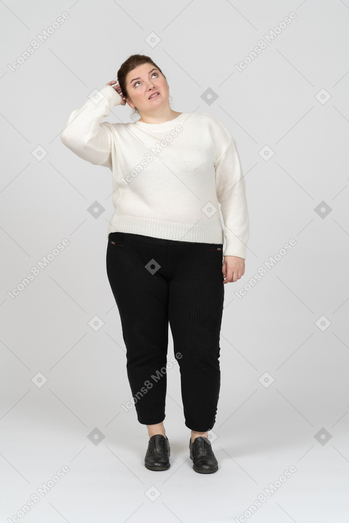 Vista frontal de uma mulher plus size com roupas casuais pensando