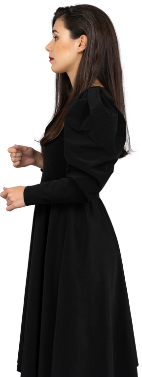Vista laterale di una giovane donna in un abito nero, alzando le mani