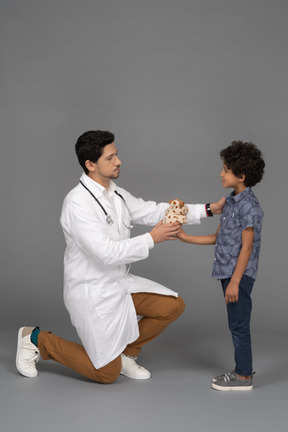 Doctor dando un juguete al niño