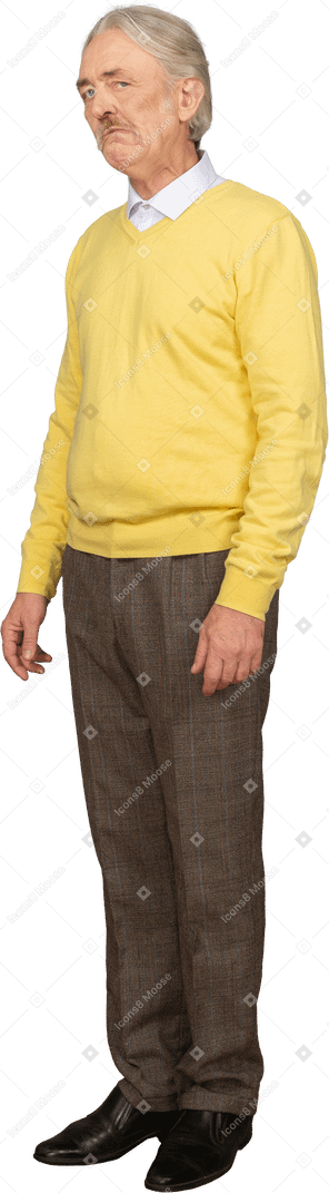 Vista de tres cuartos de un anciano triste en un jersey amarillo mirando a la cámara