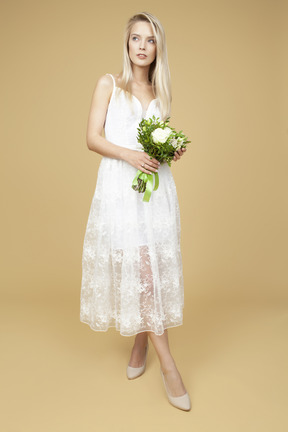 Beauitufl bride holding wedding bouquet and posing for a photo