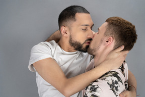 Flache lage von zwei jungen männern, die auf dem boden liegen und küssen
