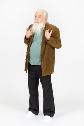 Elderly man pointing at himself and looking confused