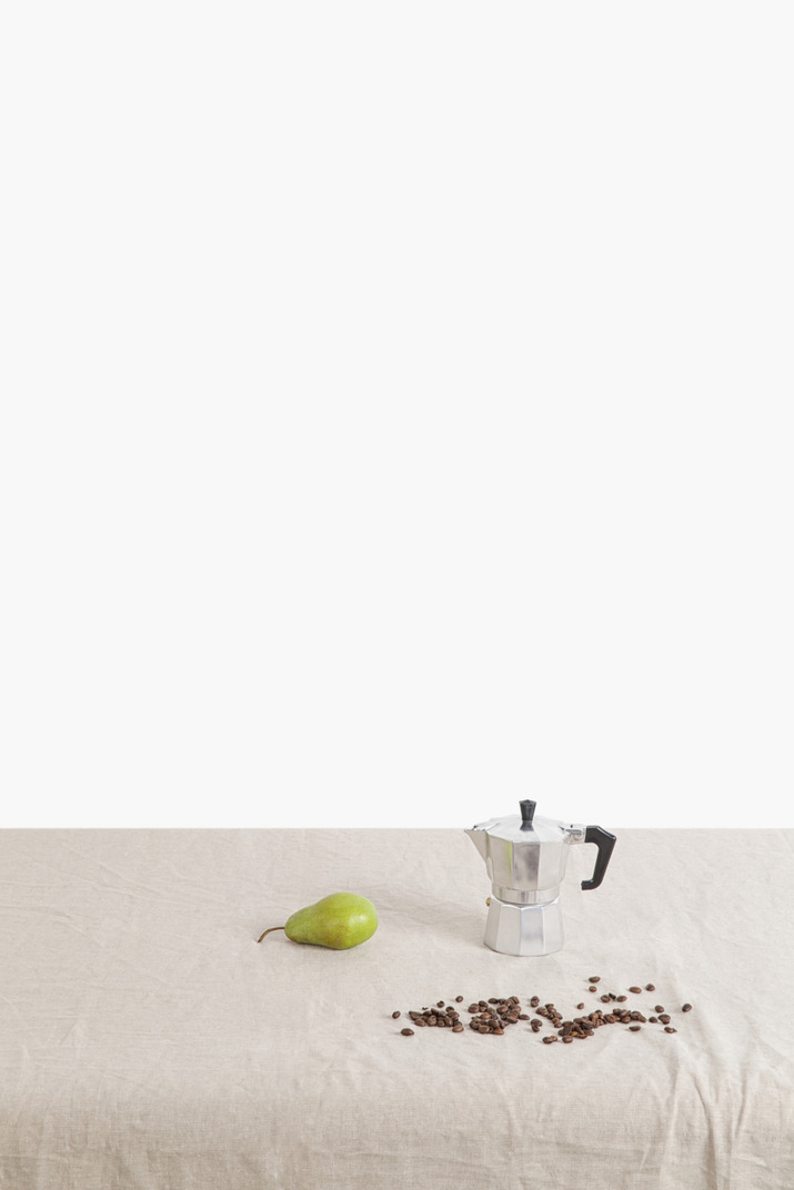 Green pear, coffee pot and scattered coffee beans