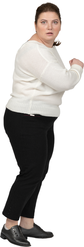 Scared plus size woman in casual clothes looking at camera