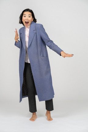 Excited woman in a coat gesturing