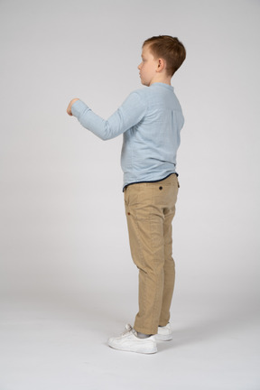 Vista lateral de um menino apontando com o dedo