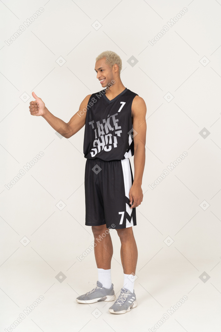 Three-quarter view of a young male basketball player showing thumb up