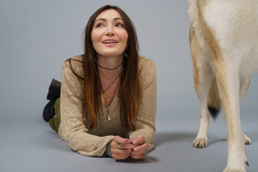 Pleine longueur d'une maîtresse couchée et son chien de départ