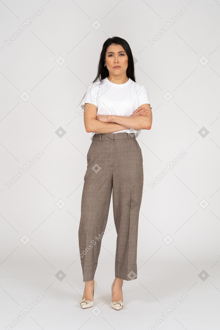 Front view of a naughty young lady in breeches and t-shirt crossing hands