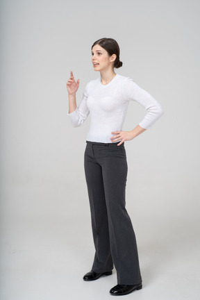 Vista frontale di una donna in abito che indica con un dito