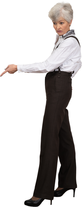 Side view of an old lady in office clothing pointing down