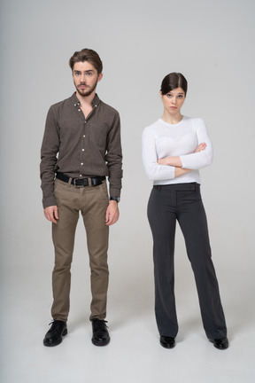 Front view of a questioning young couple in office clothing