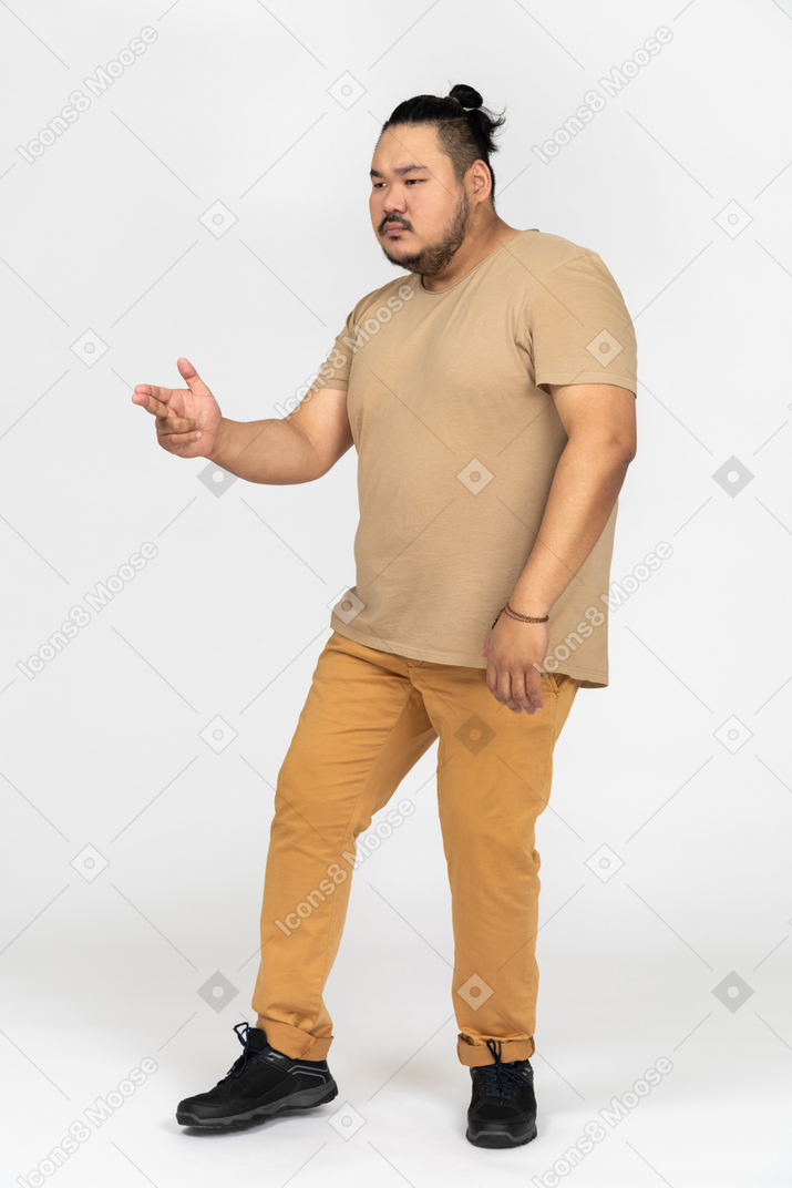 Homem asiático gordo fazendo um gesto de arma