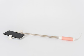 Selfie stick mit einem smartphone auf einem weißen hintergrund