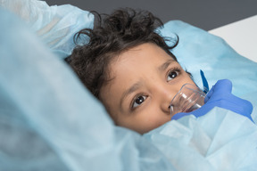 Médico colocando máscara de oxigênio no menino