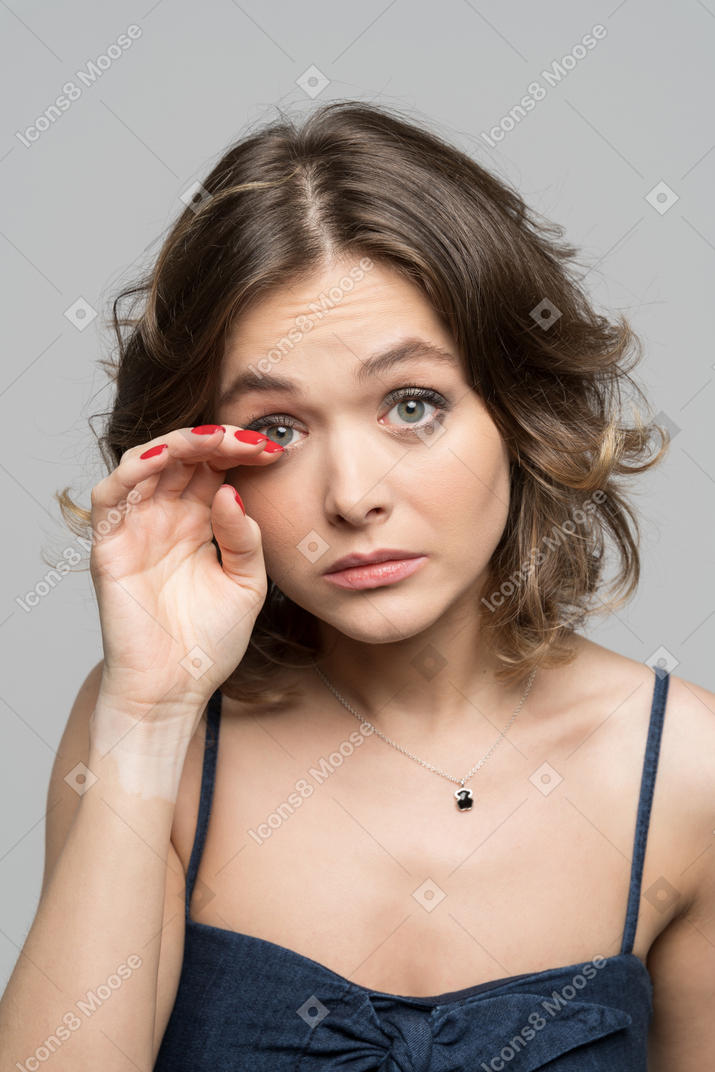Linda garota bonita ajustando a maquiagem dos olhos
