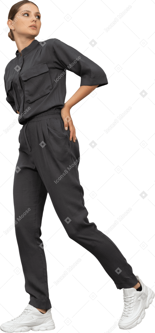 Three-quarter view of a walking young woman in a jumpsuit