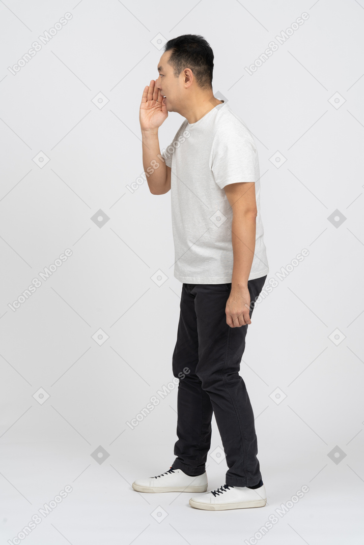 Side view of a man in casual clothes calling someone