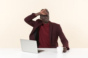 Elegante homem negro sentado à mesa no escritório