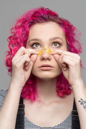 Teenage girl applying plaster on injured nose