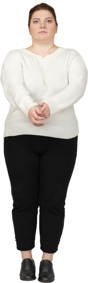 Front view of a plus size woman in casual clothes rolling up her sleeve