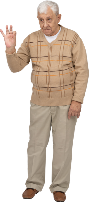 Vista frontale di un uomo anziano in abiti casual che mostra segno giusto