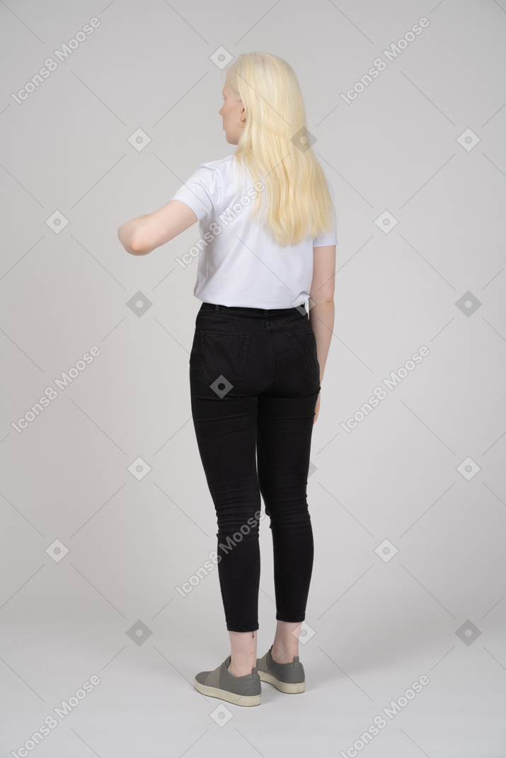 Rear view of a young blonde girl standing