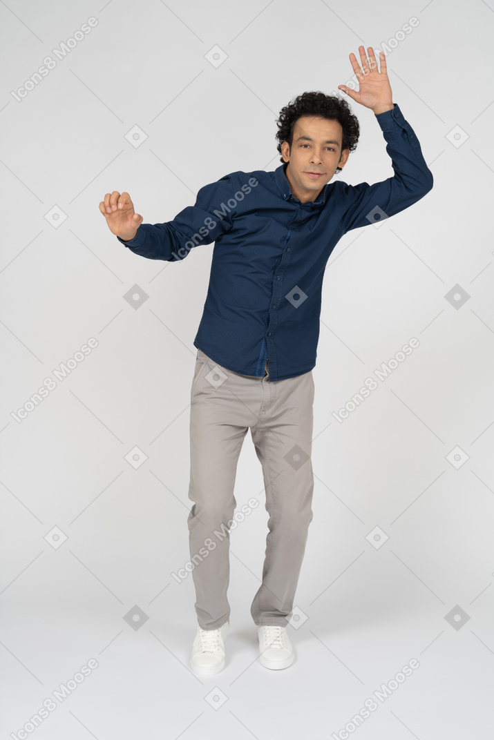 Vista frontal de um homem com roupas casuais em pé com o braço levantado