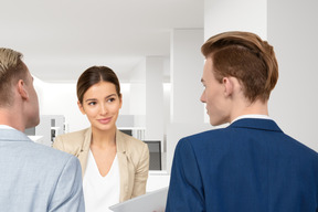 Three business people talking to each other in an office