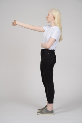 Vista lateral de uma mulher de cabelos compridos, levantando o braço